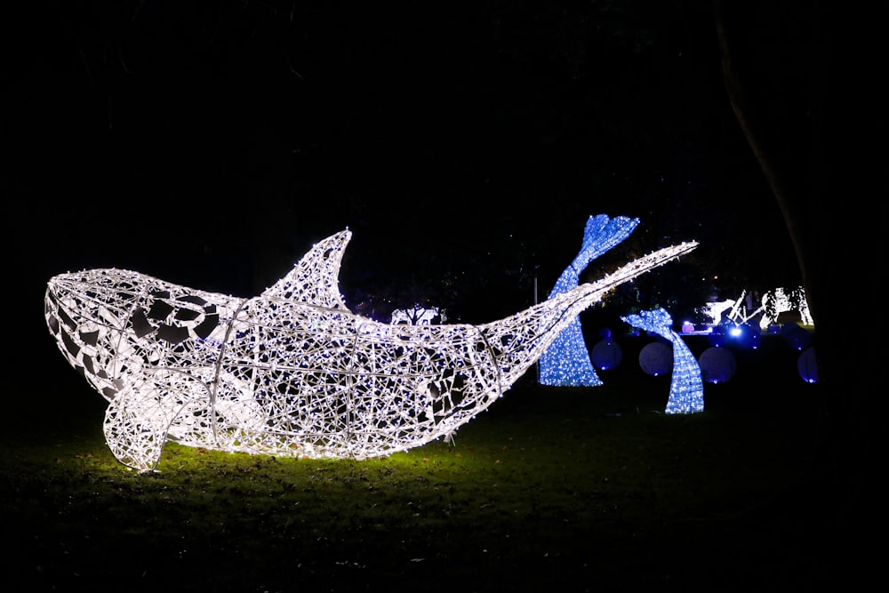 a light sculpture of a whale in the dark