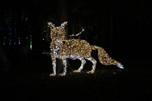 Close-up of a powder-coated metal fox silhouette with intricate leaf patterns, glowing softly in natural light.
