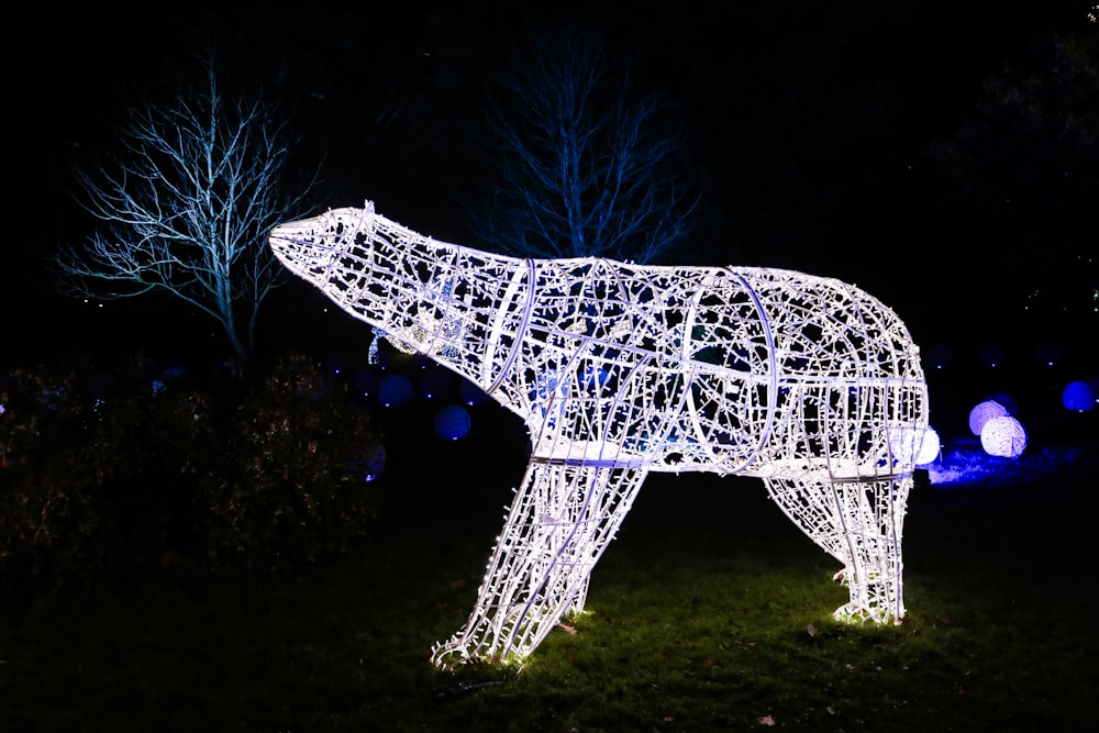 a lit up polar bear in a field at night