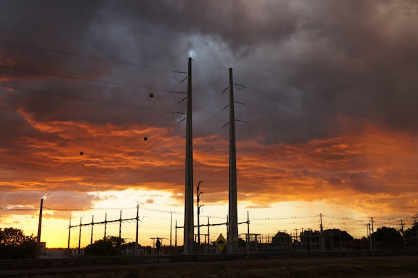 High-voltage cable installation team working on a large industrial site at sunset
