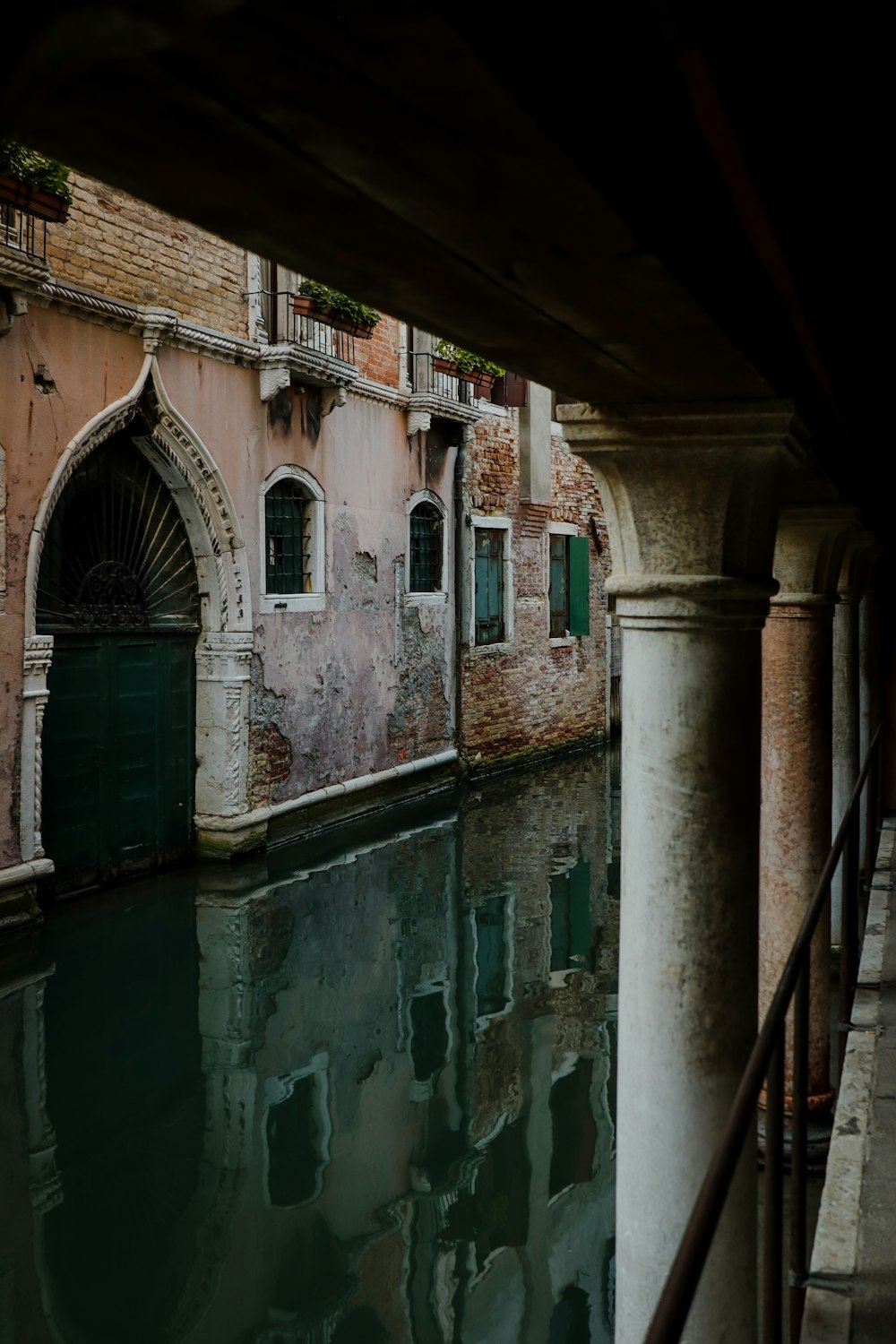 a narrow canal with a building and a green door