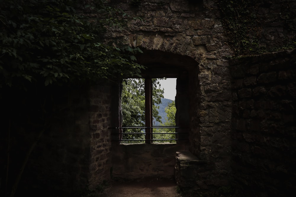 a window in a stone building with a view of a mountain