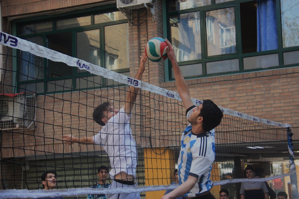 a couple of men playing a game of volleyball