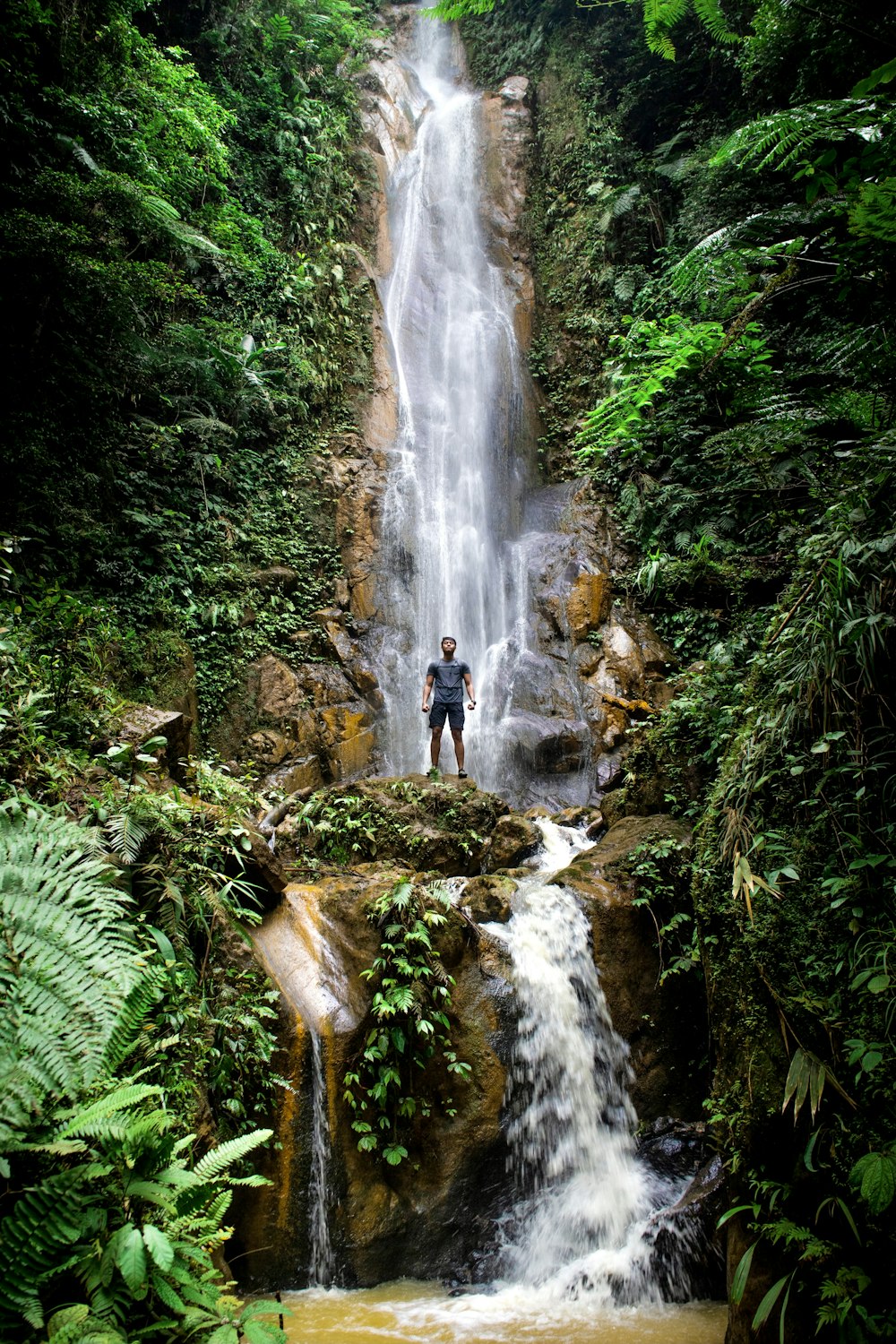 a man standing in front of a waterfall