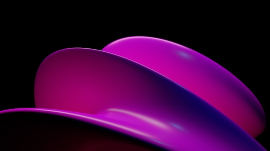 A surreal composition showcases smooth, curved shapes in shades of pink and purple against a dark backdrop. The objects seem to be abstract forms, potentially representing a modern or futuristic theme.
