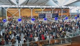 A vibrant photo of a bustling airport terminal filled with travelers checking in.