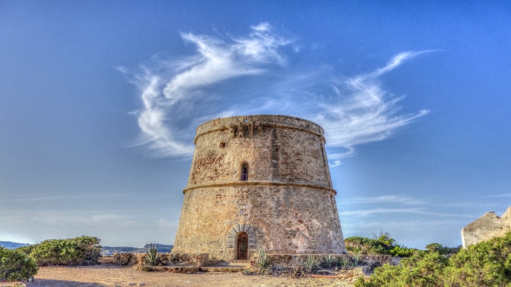 a stone tower sitting on top of a dirt field