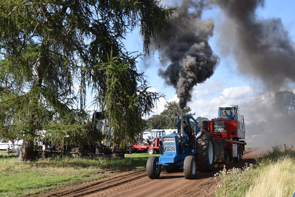 a tractor pulling a trailer down a dirt road