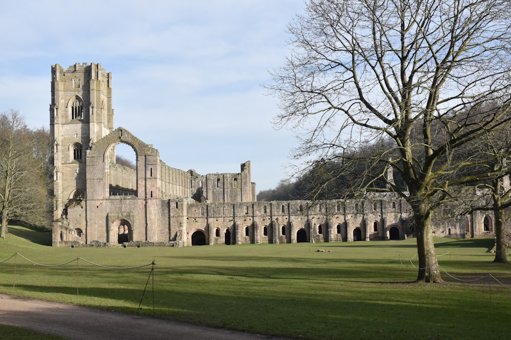 a large stone building sitting on top of a lush green field