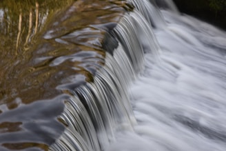 a close up of a small waterfall with brown water