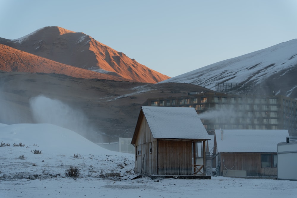 a small cabin in the middle of a snowy field