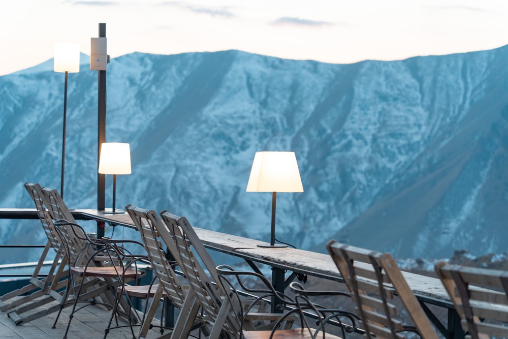 a table with chairs and lamps on top of a mountain