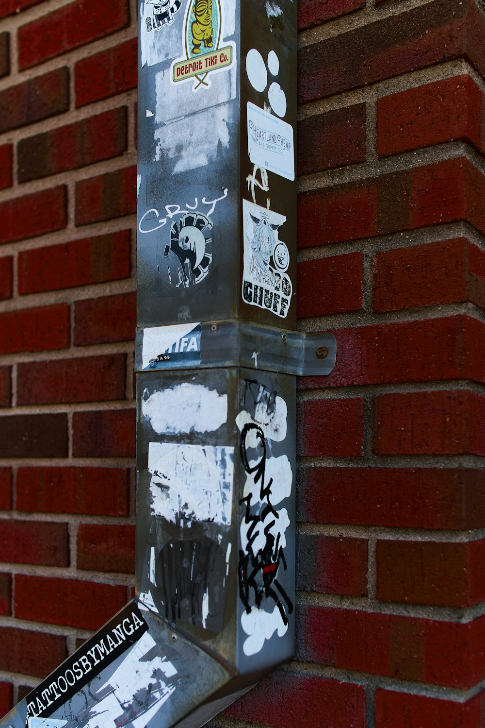 a parking meter covered in graffiti on the side of a building