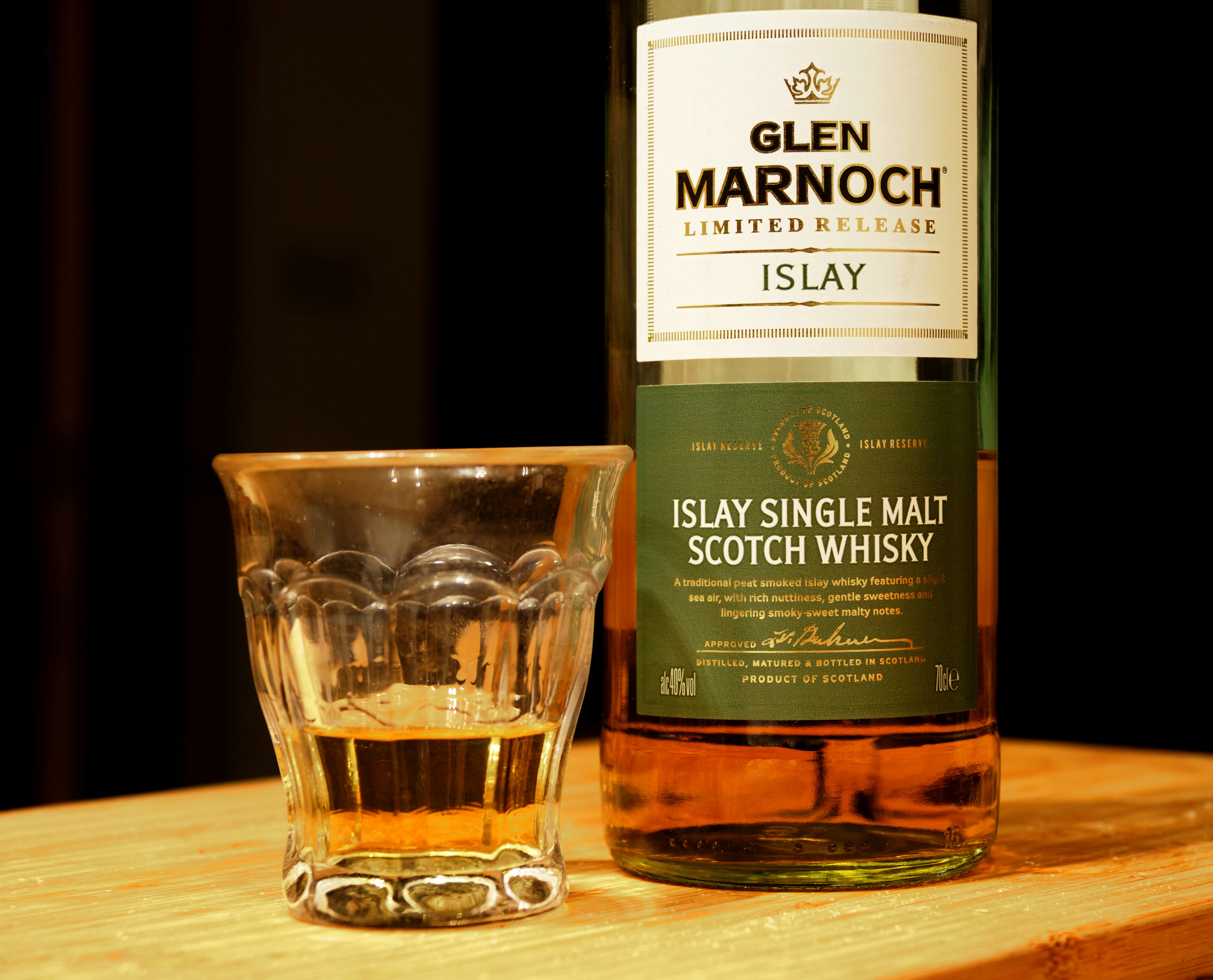 a bottle of whisky next to a shot glass