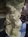 A detailed marble sculpture depicting intertwined figures in a dramatic pose, located inside a richly decorated building. The craftsmanship focuses on intricate detailing of human anatomy and expressions. Background elements include wooden furniture and elaborate wall decorations.