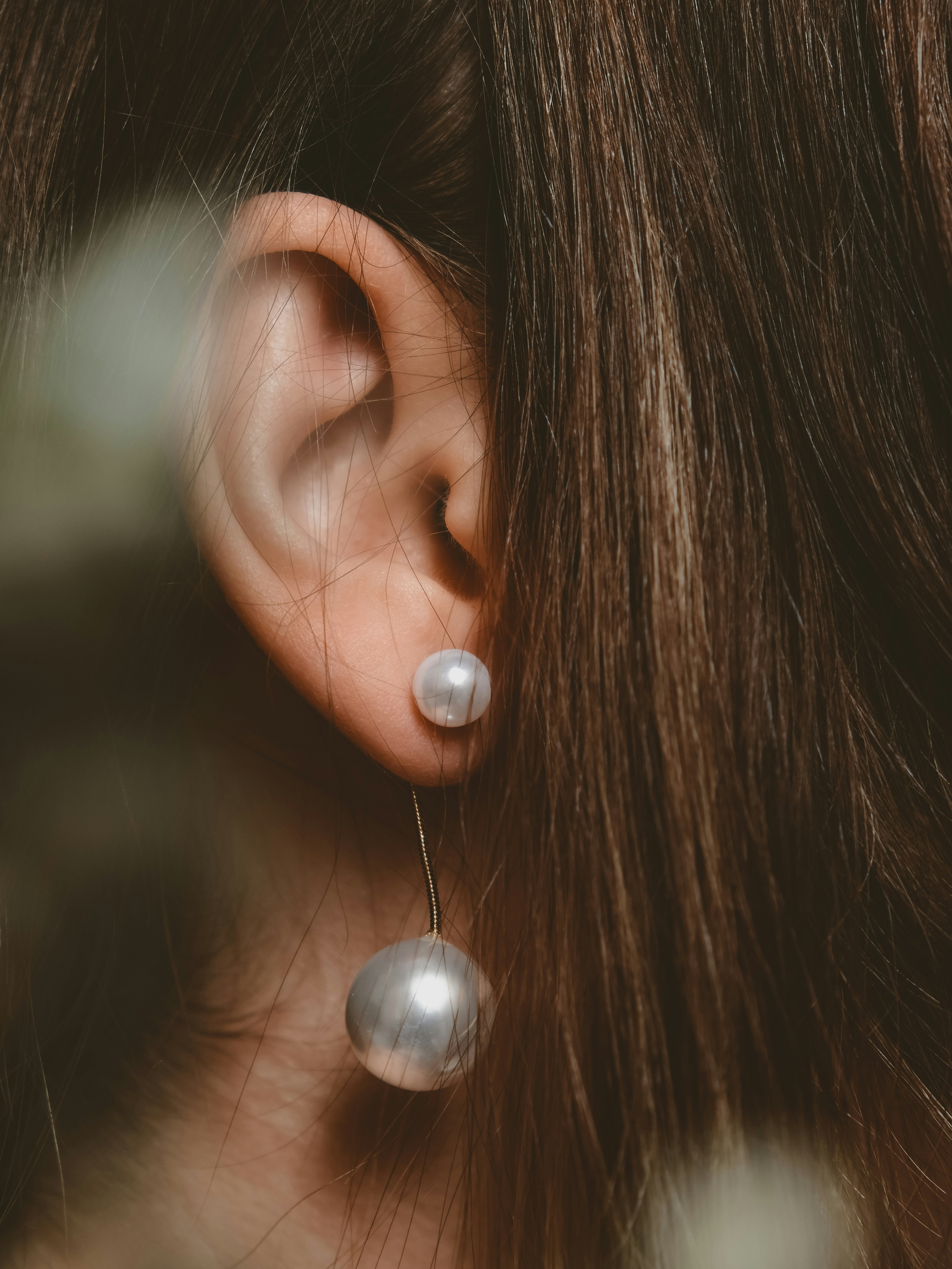 a close up of a person wearing a pair of earrings