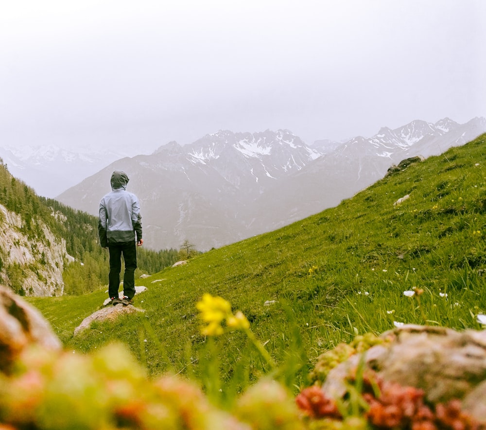 a man standing on top of a lush green hillside