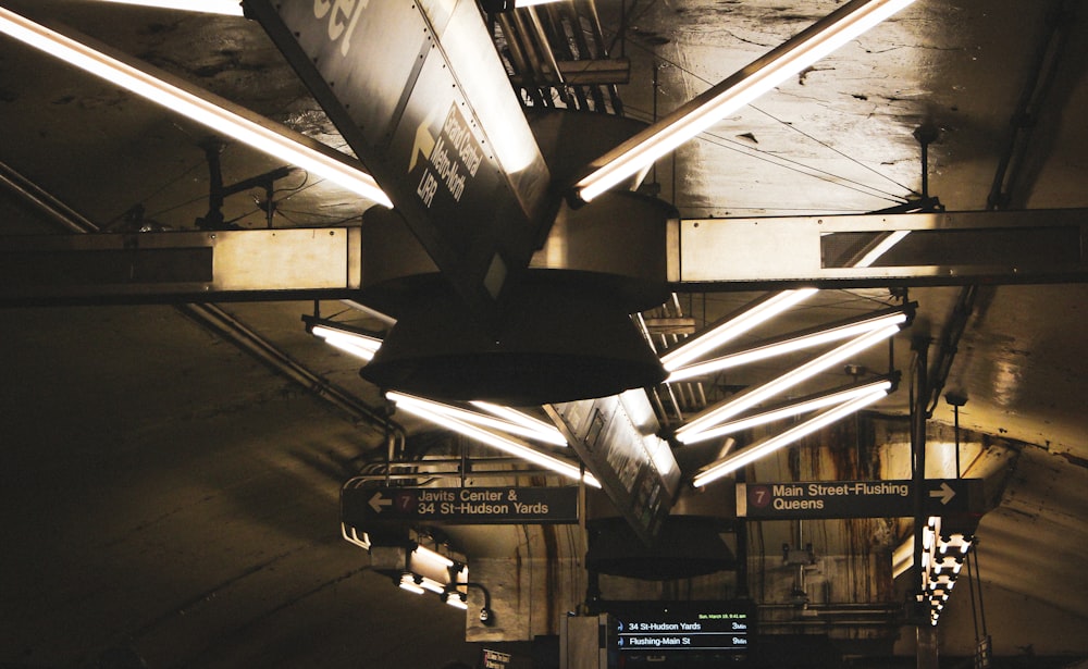 a train station with a bunch of lights hanging from the ceiling