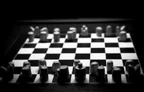 a black and white chess board with pieces on it