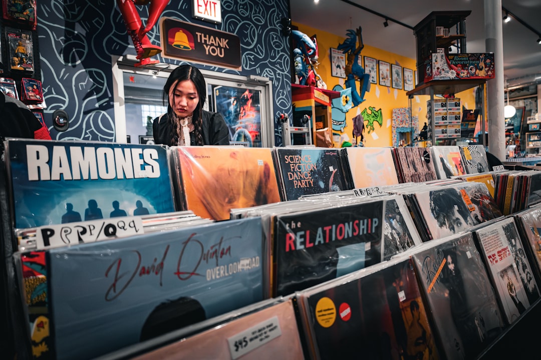 a woman standing in front of a display of records,