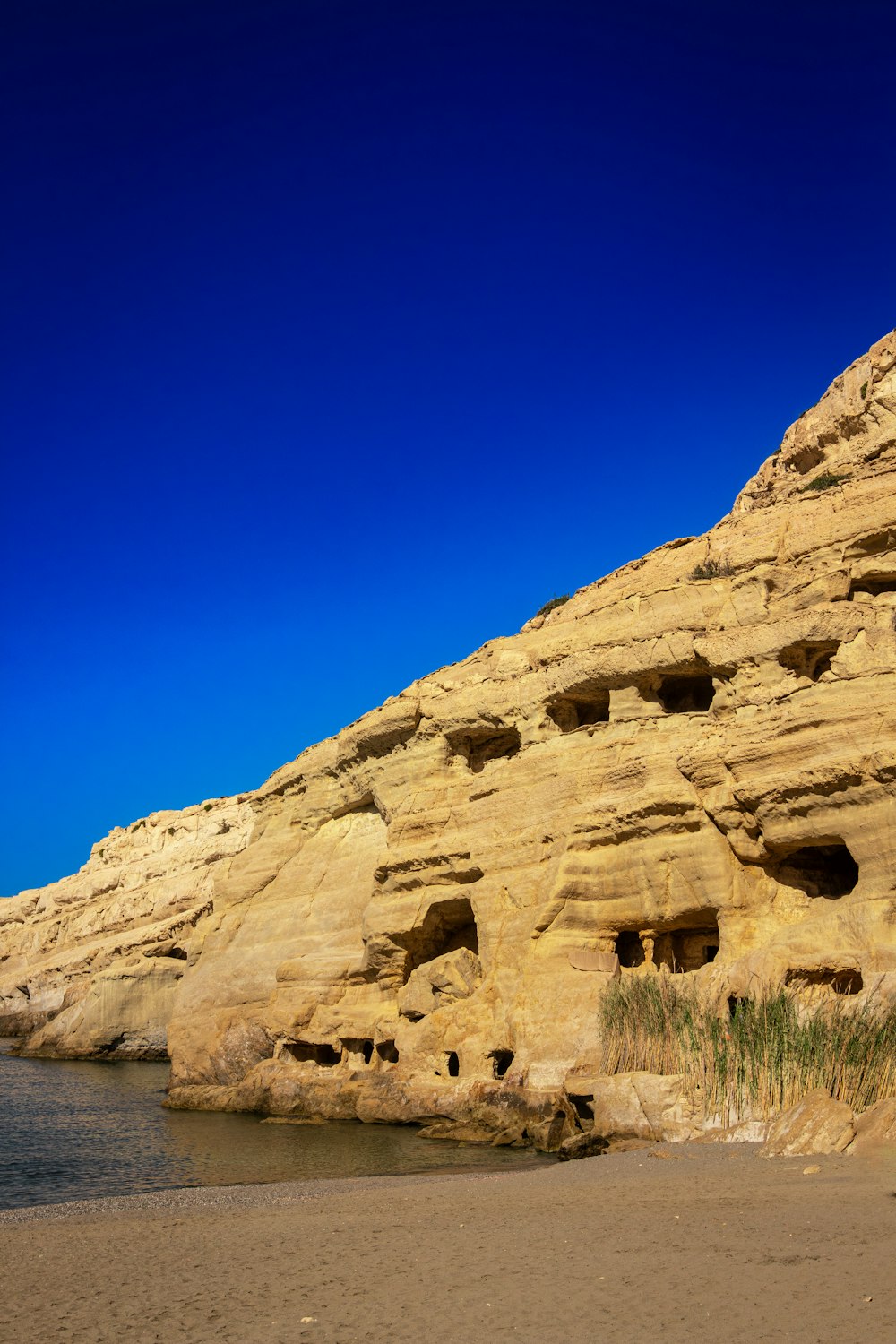 a rocky cliff with holes in the side of it