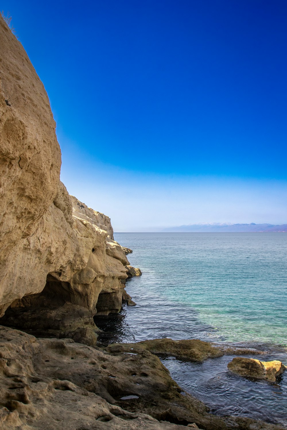 a man standing on a cliff next to the ocean