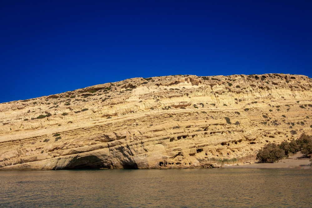 a large rock formation on the side of a body of water