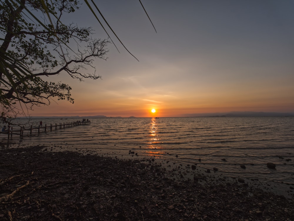 the sun is setting over a body of water