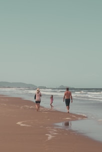 A family enjoying a beach vacation with clear blue skies and gentle waves.