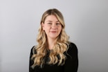 a woman with long blonde hair wearing a black shirt