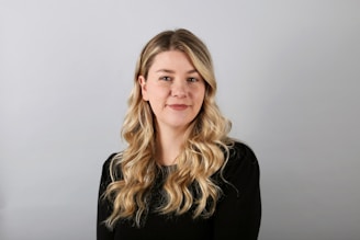 a woman with long blonde hair wearing a black shirt