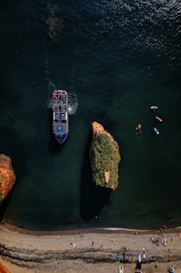 Drone filming a group of tourists enjoying a boat ride near the rocky coastline of Búzios.