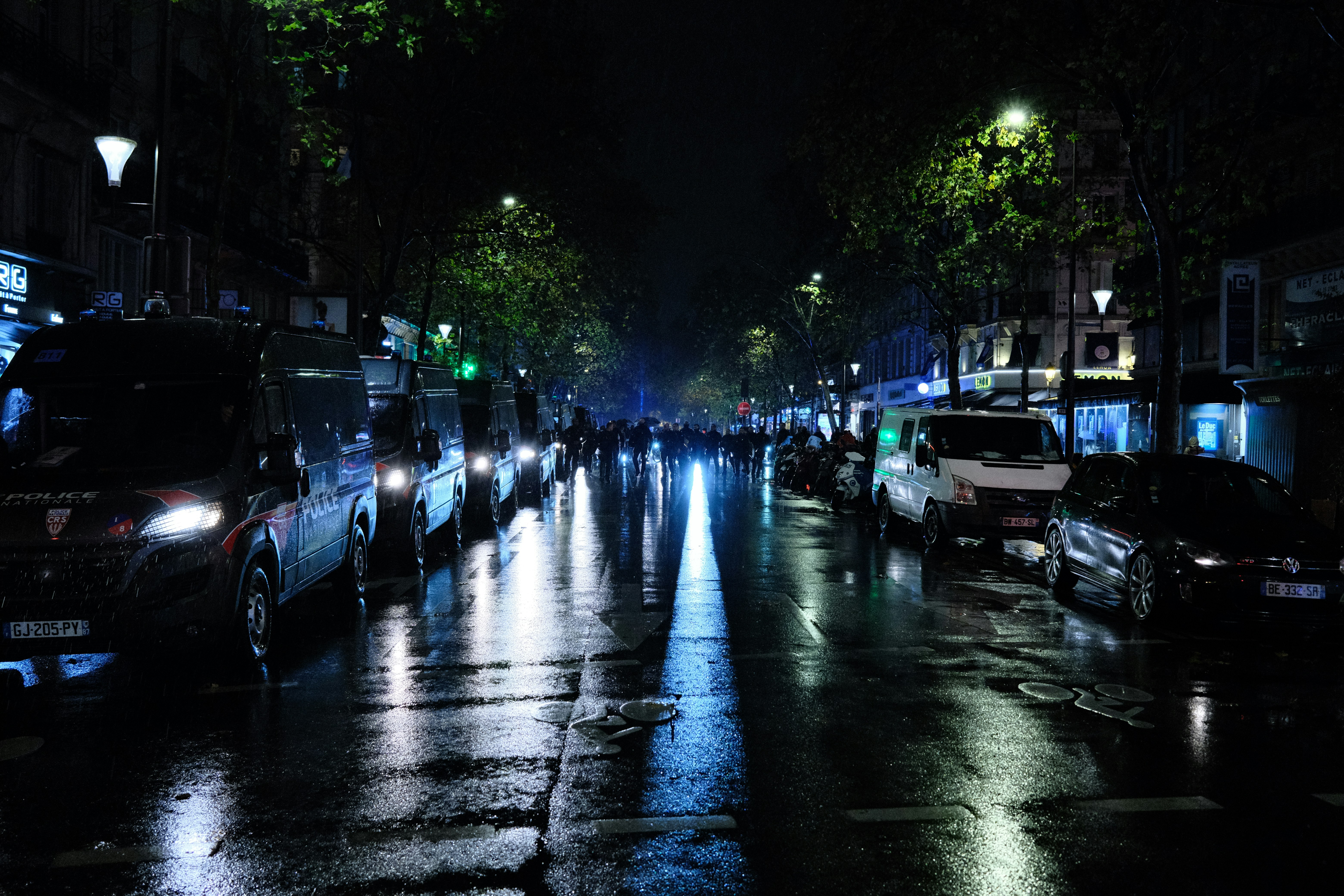 a group of people walking down a street at night