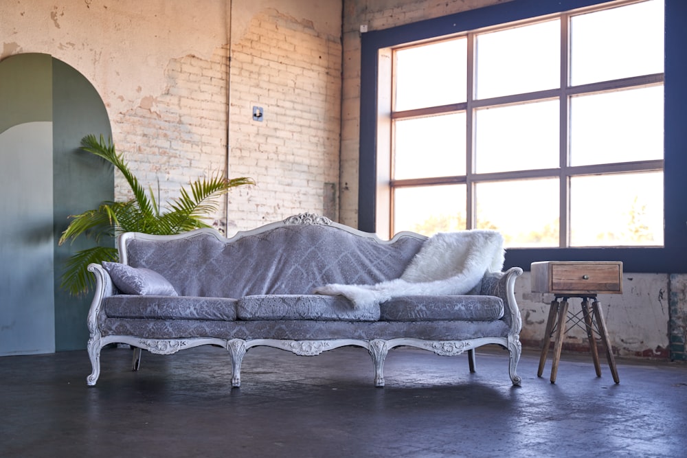 a couch sitting in a room next to a window