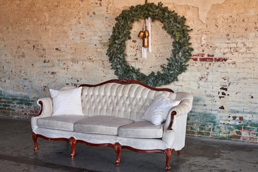 a couch sitting in front of a brick wall