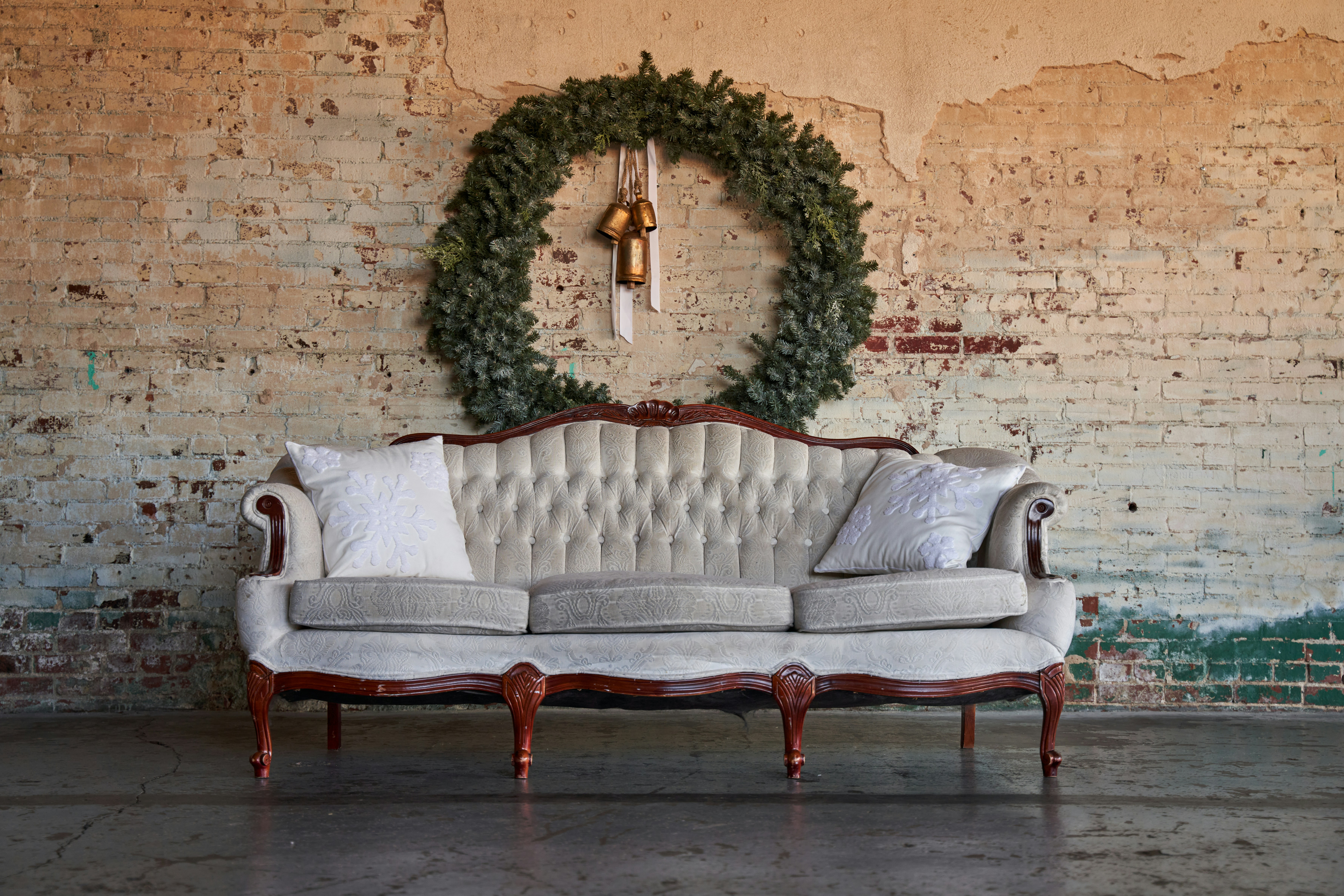 a couch sitting in front of a brick wall