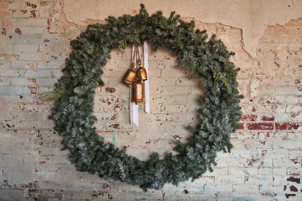 a wreath with bells hanging on a brick wall