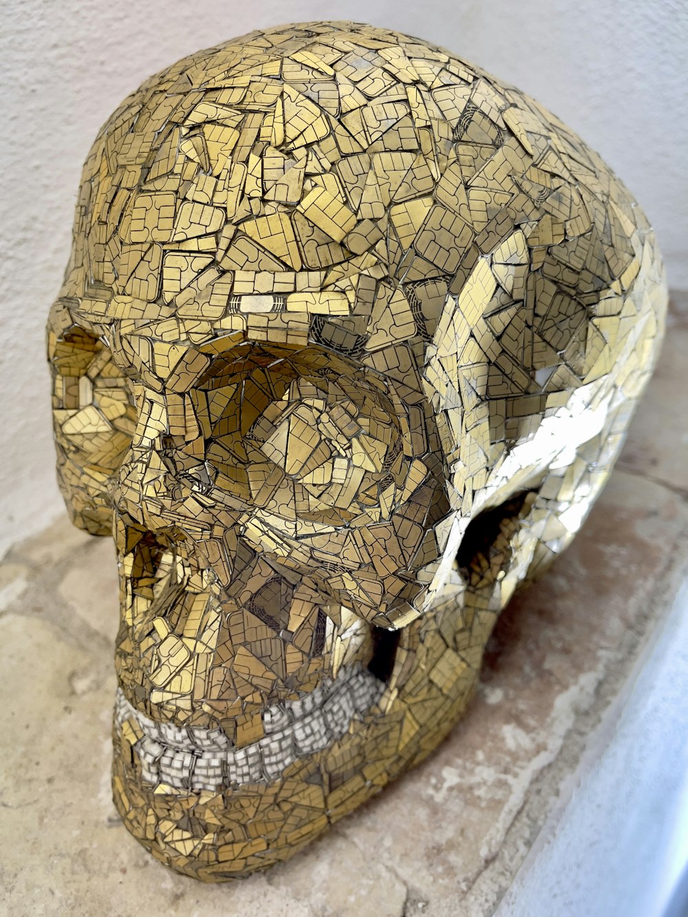 a mosaic skull sitting on top of a stone slab