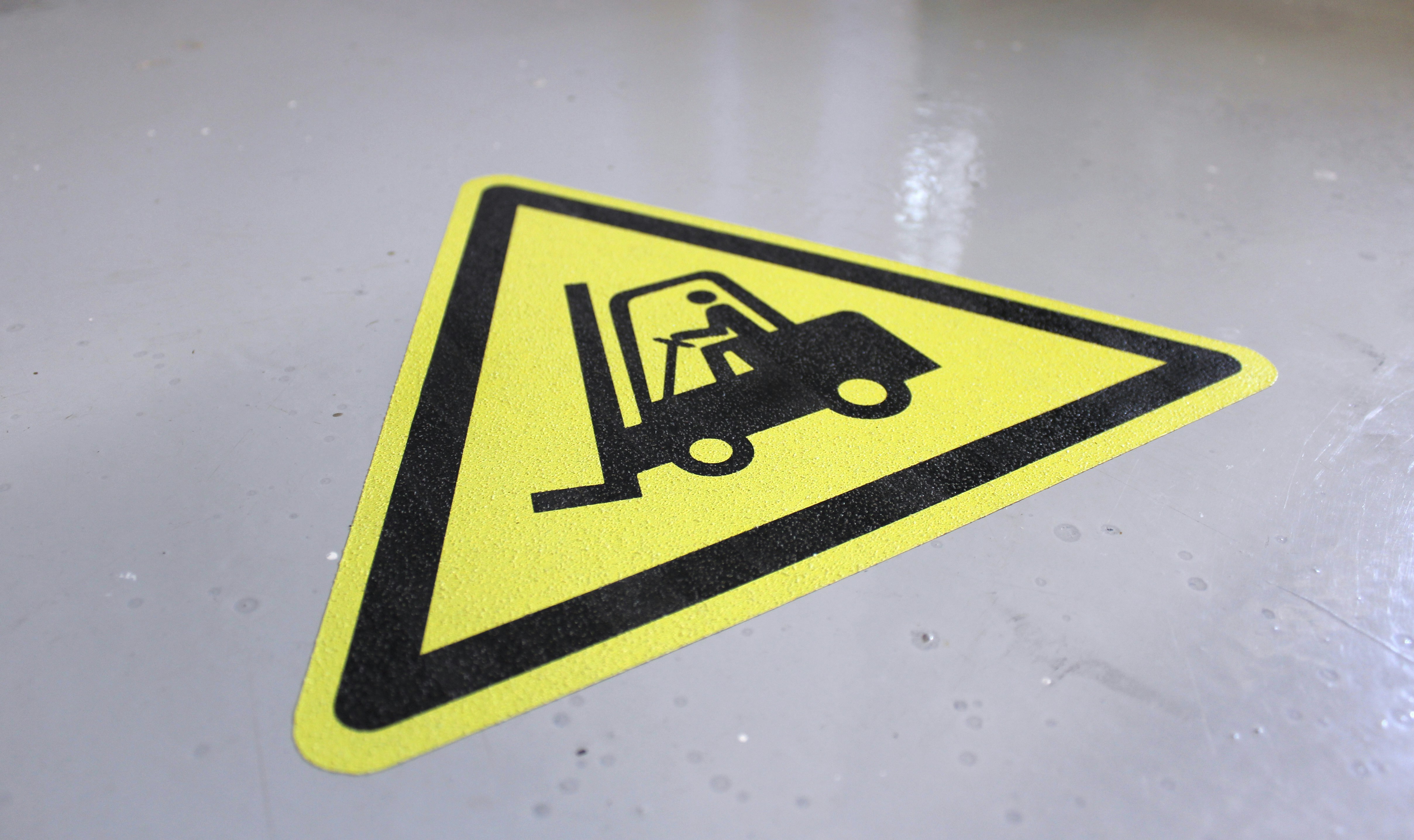 a yellow sign with a fork lift on it