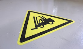 a yellow sign with a fork lift on it