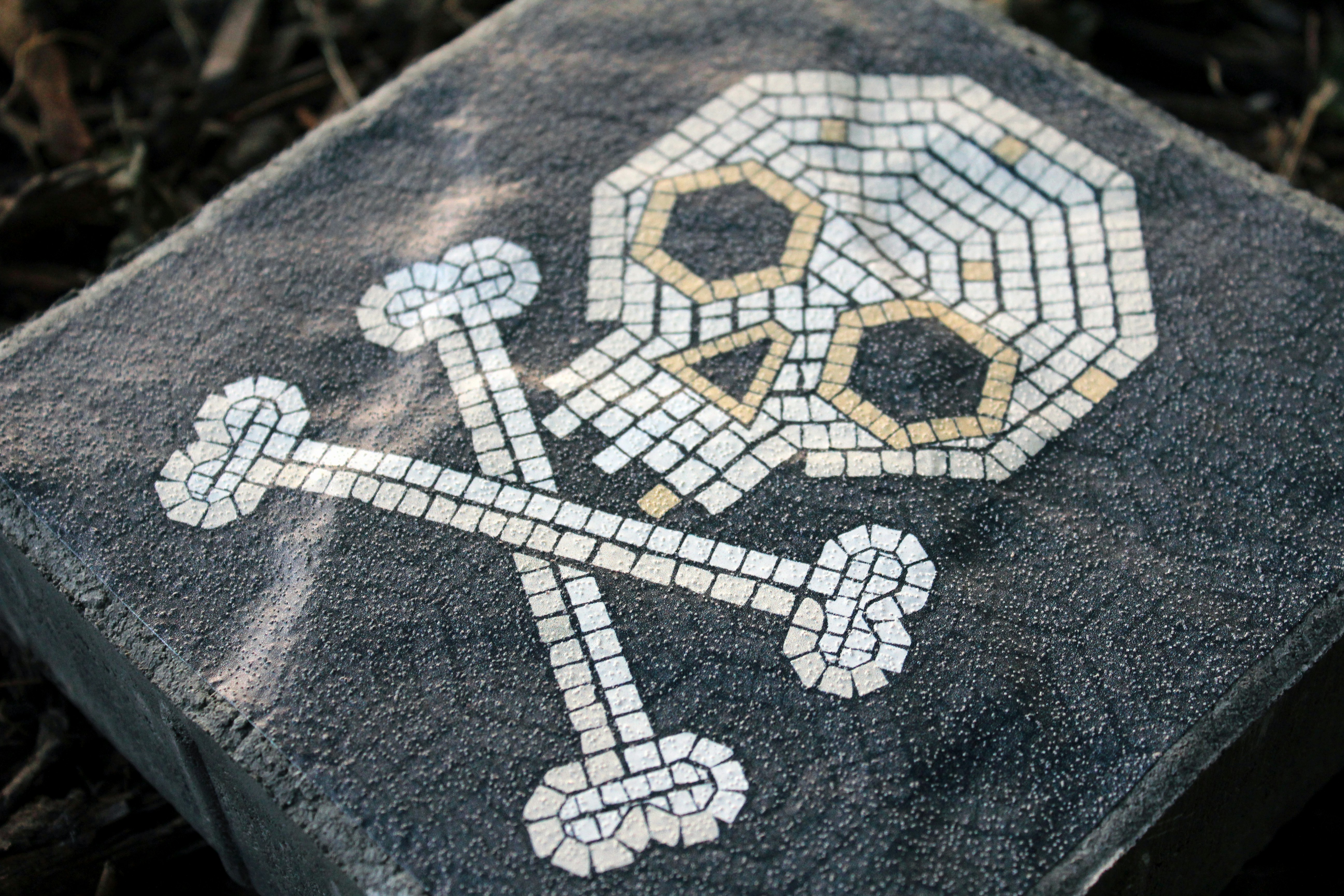 a mosaic tile with a cross and a skull on it