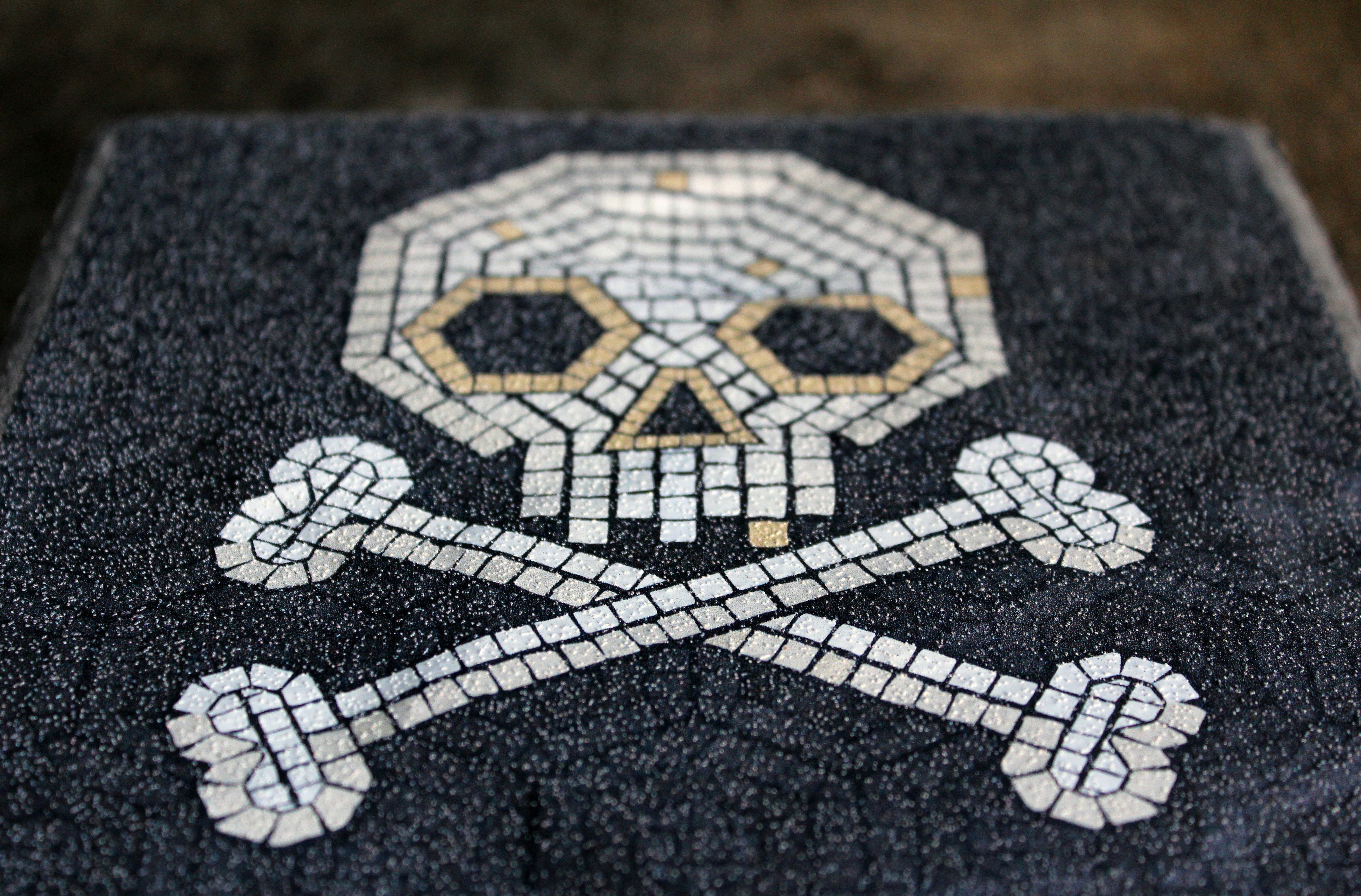 a mosaic skull and crossbones on a door mat