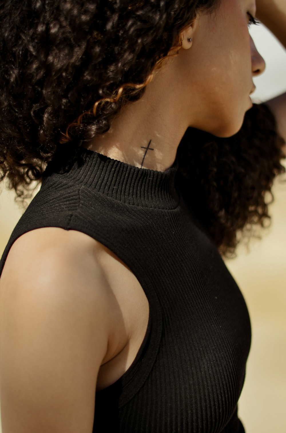 a woman with a cross tattoo on her neck