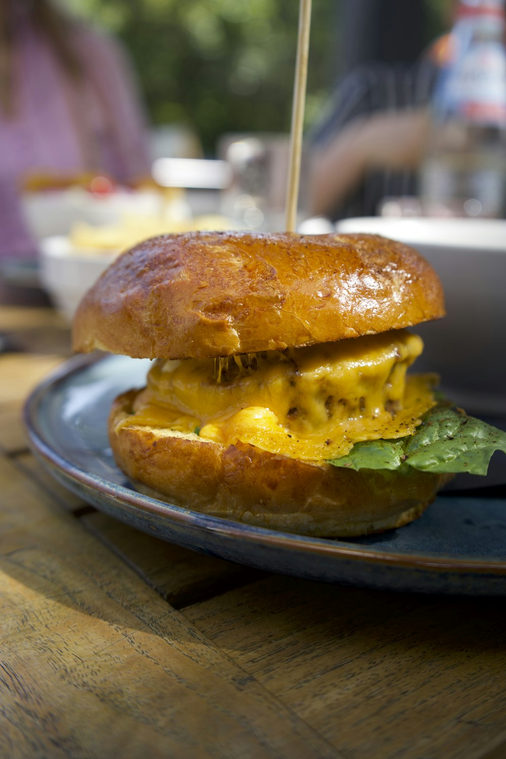 a sandwich on a blue plate on a wooden table