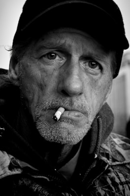 A black-and-white portrait of a biker with a weathered face and confident smile.