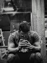 A gym owner reviewing analytics on a mobile device with a satisfied smile.