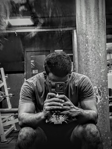 A person using a smartphone app to follow a personalized workout plan in a bright gym setting.