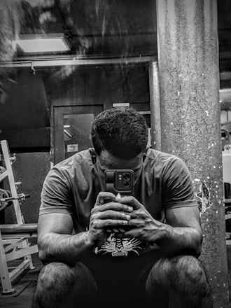 A focused athlete reviewing supplement options on a digital tablet in a bright gym setting.