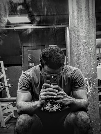A focused trainer reviewing a workout plan on a tablet in a dimly lit gym.