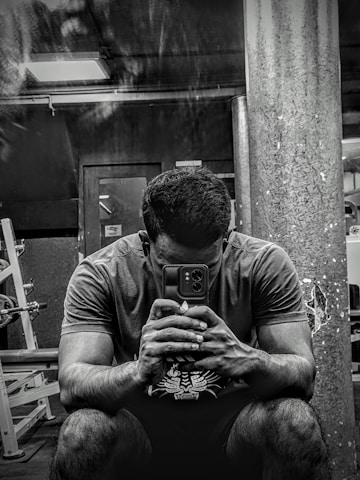 A person using a fitness app on their smartphone while exercising at home.